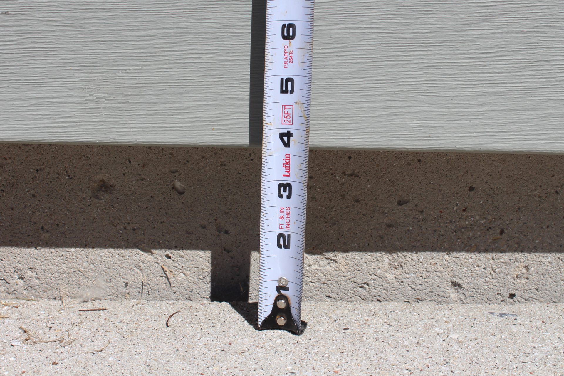 Settled driveway panel with visible drop before concrete lifting